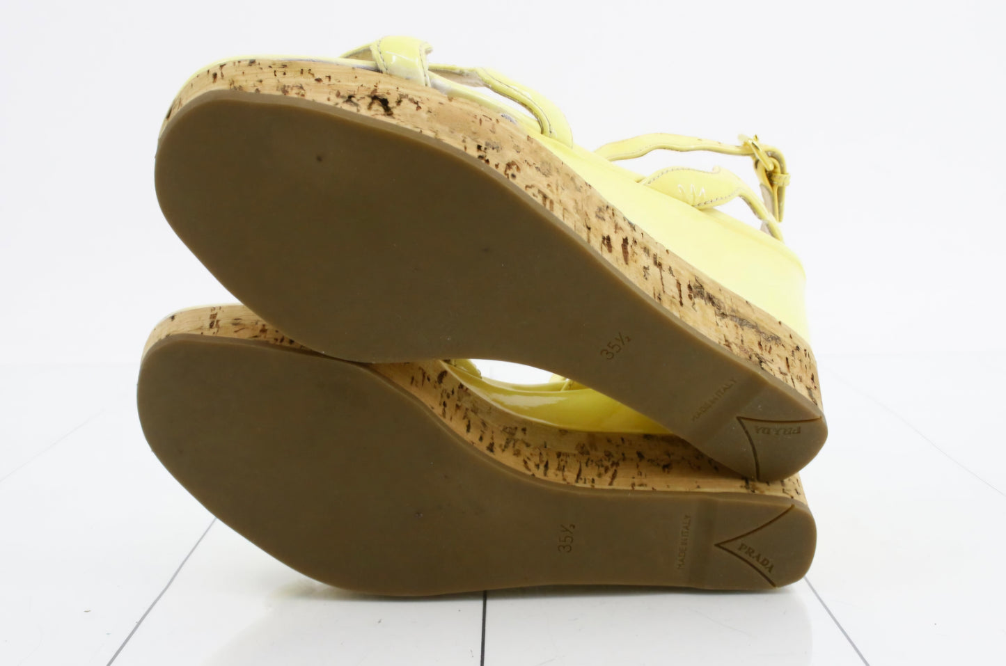 Prada Patent Leather Wavy Strap Wedge Sandals in a light butter yellow hue.