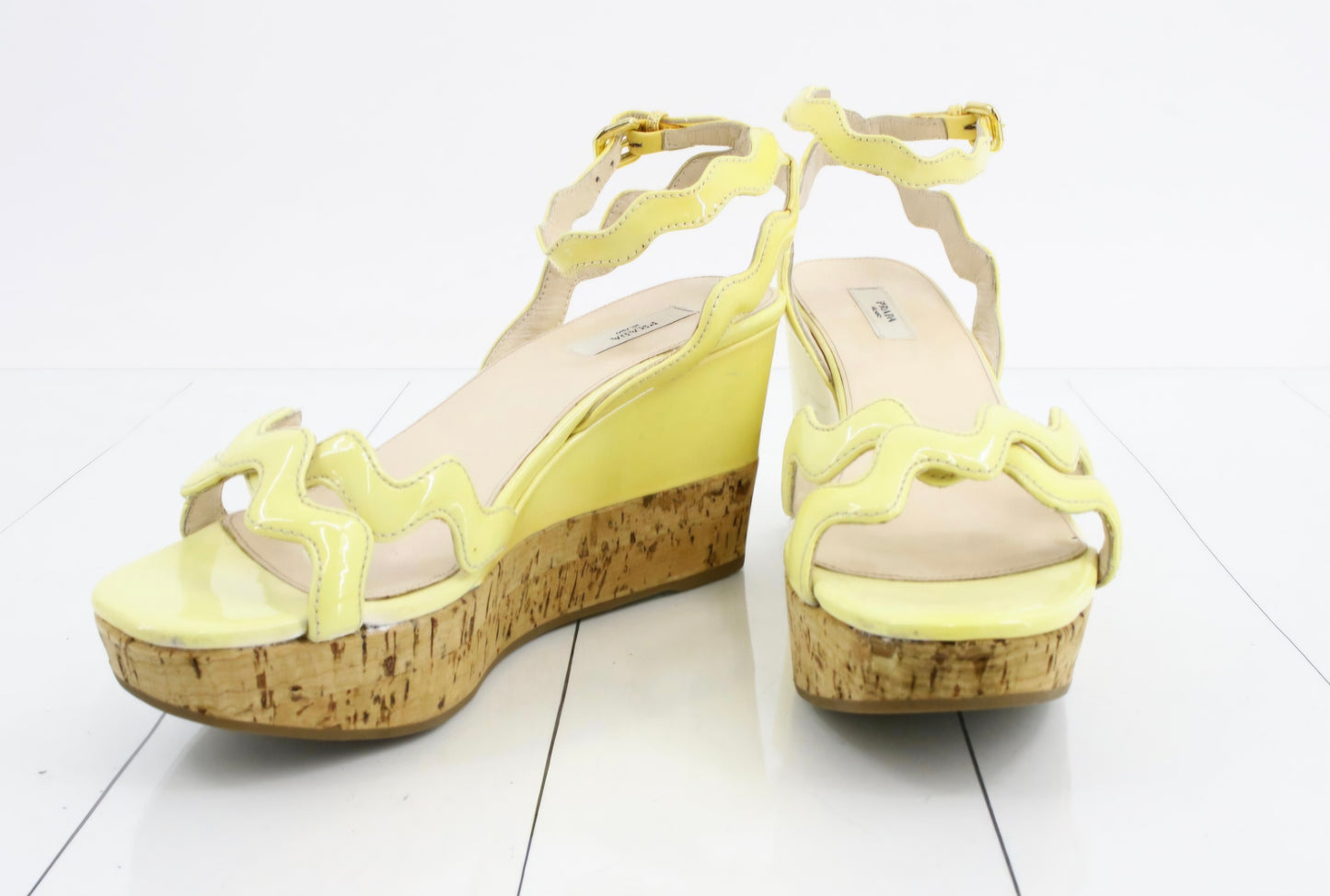Prada Patent Leather Wavy Strap Wedge Sandals in a light butter yellow hue.