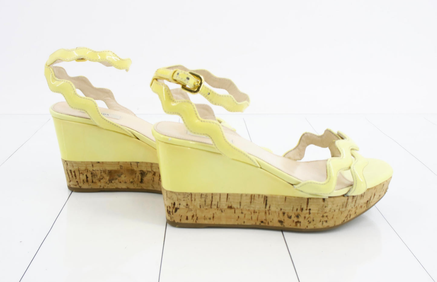 Prada Patent Leather Wavy Strap Wedge Sandals in a light butter yellow hue.